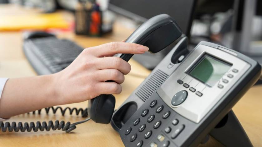 A VoIP phone with a digital display showing a VoIP phone number